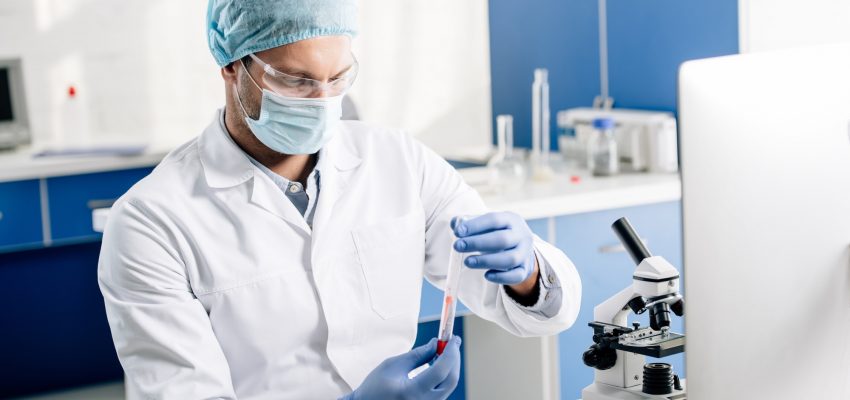 genetic consultant in white coat doing dna test in lab